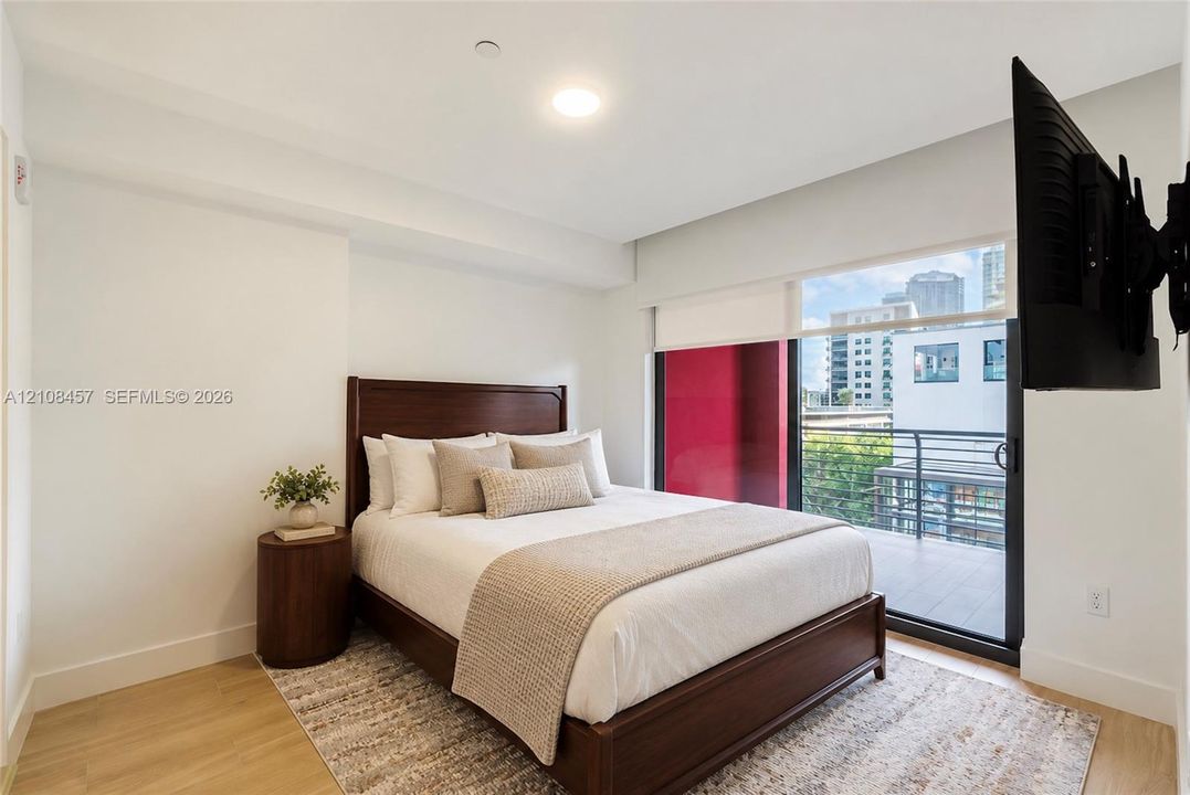 Bedroom featuring wood-finish flooring, recessed lighting, and a sliding glass door providing access to a private balcony