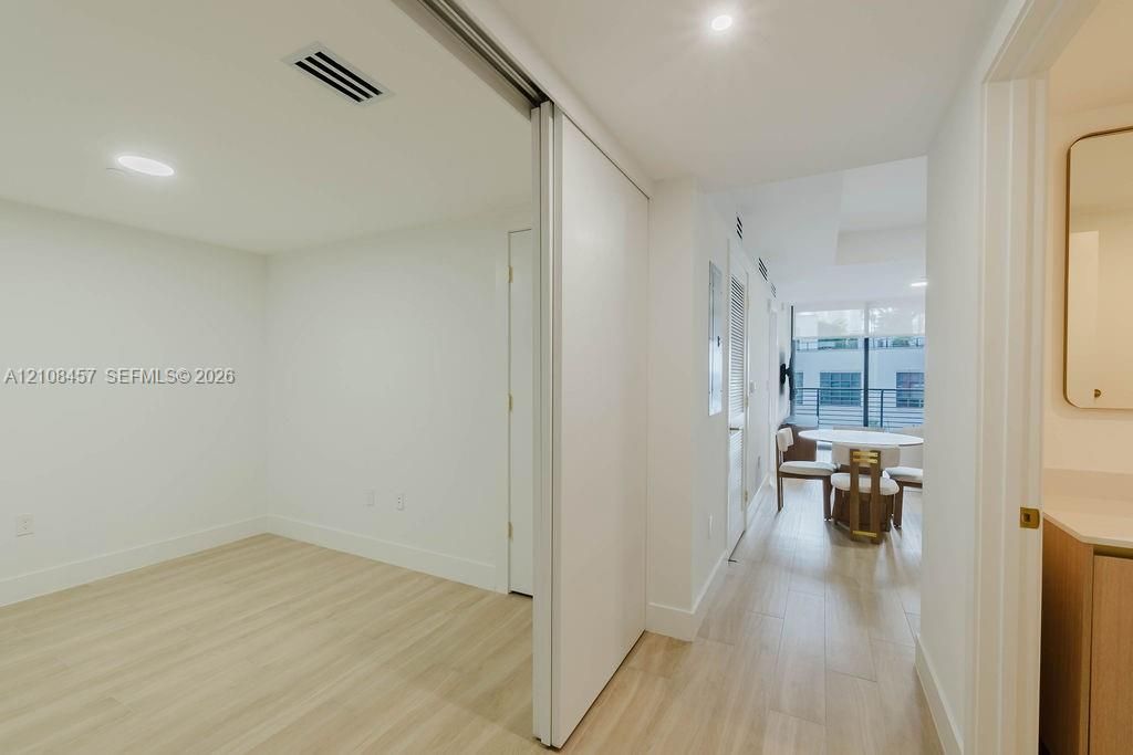Interior space featuring wood-finish flooring, recessed lighting, and a large sliding door with a mirror finish