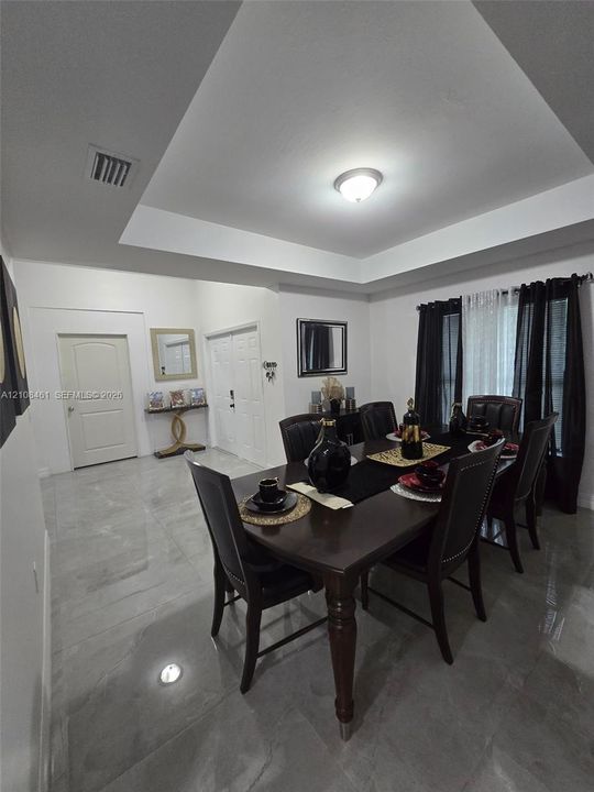 Tray ceiling, large-format tile flooring, and multi-panel interior doors