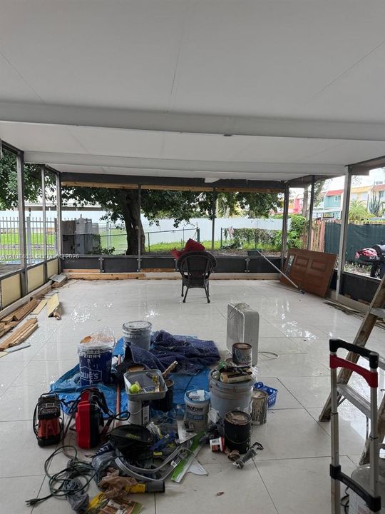 Screened-in patio featuring polished tile flooring, a solid ceiling, and metal framing