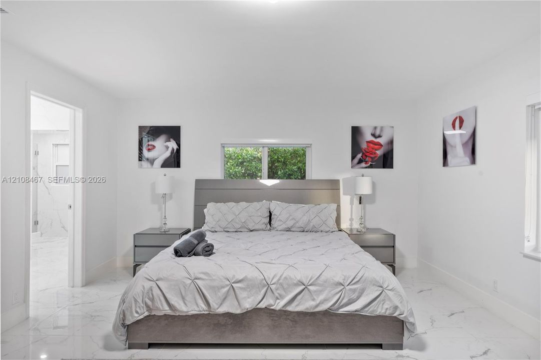 Interior space featuring high-gloss, large-format tile flooring with marble-pattern veining and a centered window