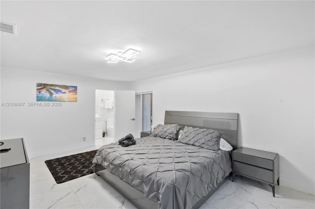 Neutral-toned interior featuring large-format tile flooring and a modern multi-tiered geometric flush-mount light fixture