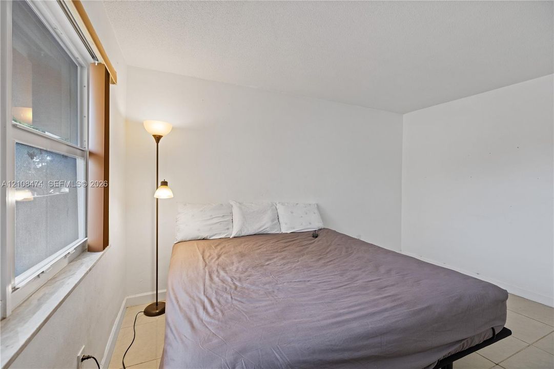 Neutral-toned tile flooring and single-hung window with a deep sill