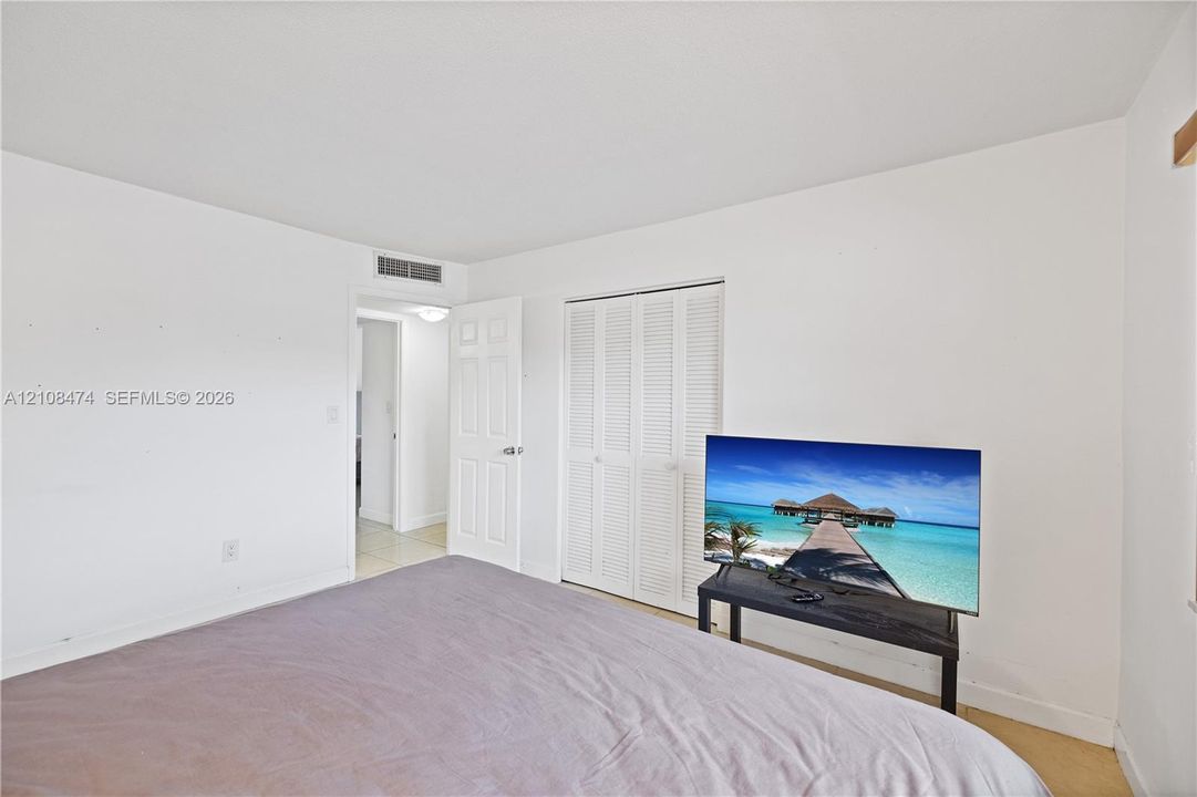 Neutral interior room featuring white walls, a white bi-fold louvered closet door, and a white interior swing door