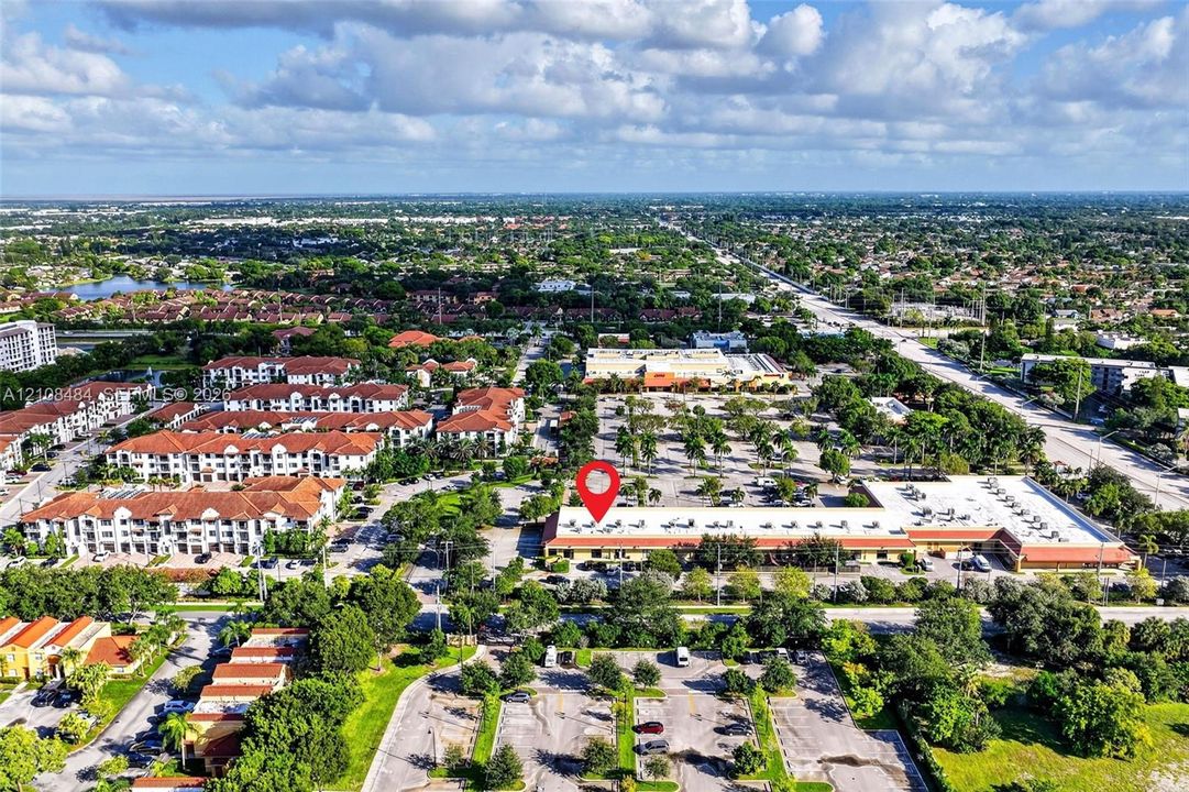Aerial perspective of a single-story commercial structure featuring a tiled roof and dedicated surface parking