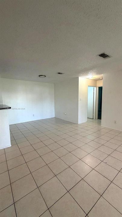 Open floor plan featuring light-colored tile flooring, neutral wall tones, and recessed lighting fixtures