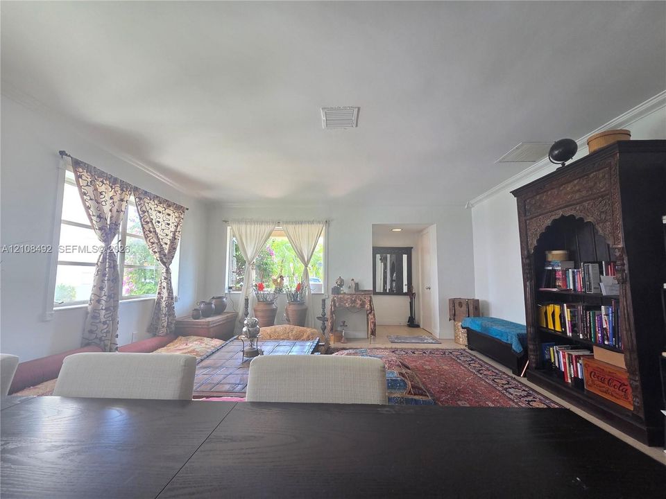 Open-concept interior featuring expansive wall space, large windows, and crown molding