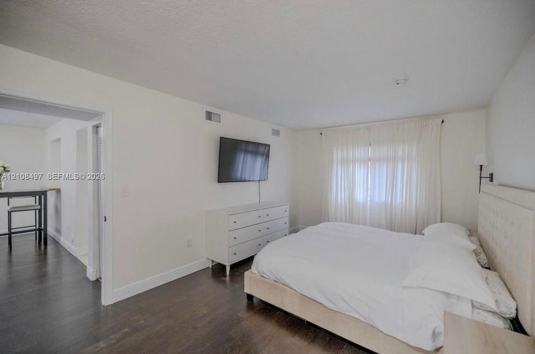 Room featuring wood-finish flooring, neutral wall tones, and a wall-mounted light fixture