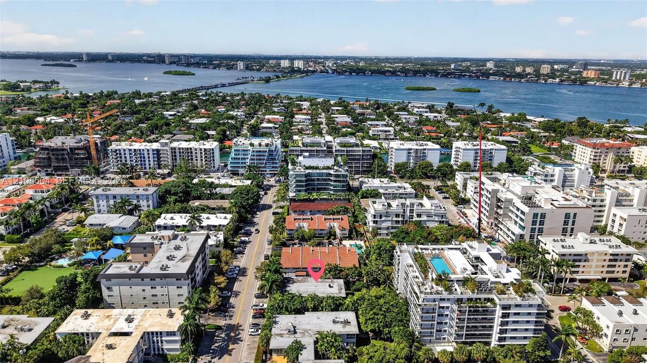 Aerial perspective featuring a property location within a dense coastal residential area, characterized by proximity to the waterfront and surrounding mature vegetation