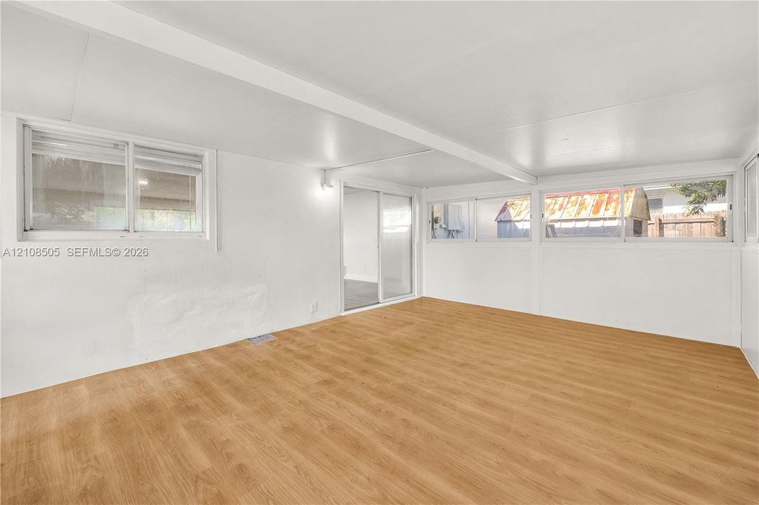 Interior space featuring wood-finish flooring, sliding glass door, and multiple horizontal sliding windows