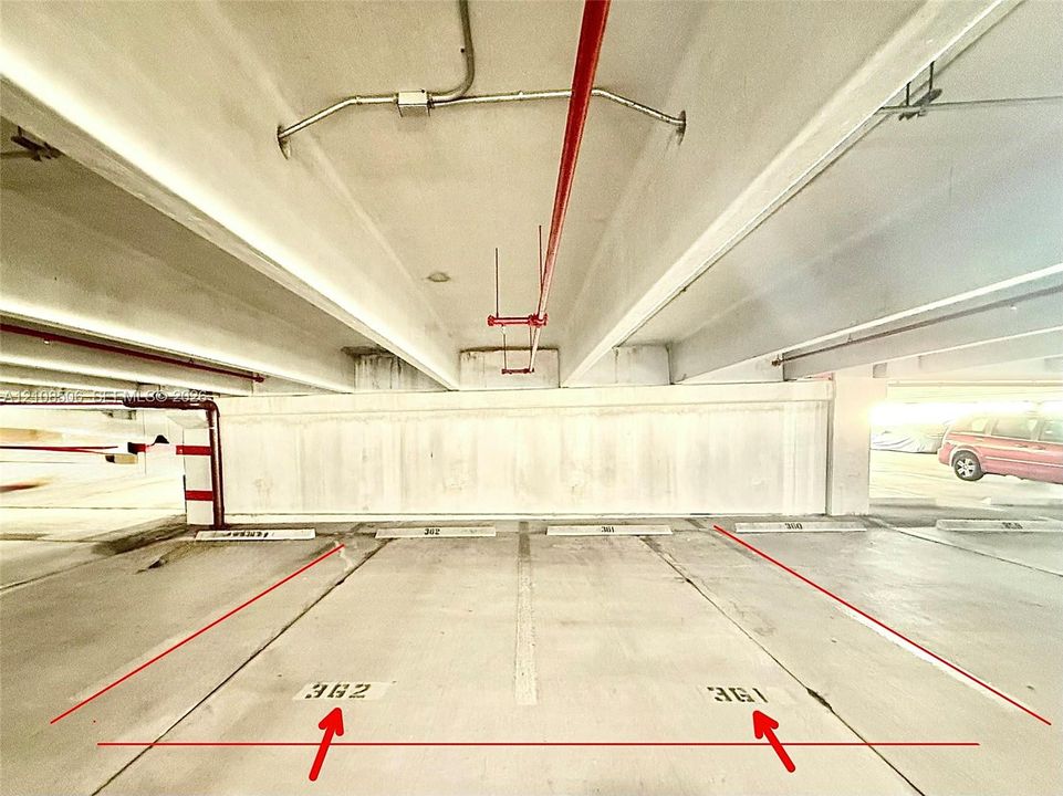 Covered parking structure featuring concrete flooring, marked stall numbers 361 and 362, and overhead fire suppression infrastructure