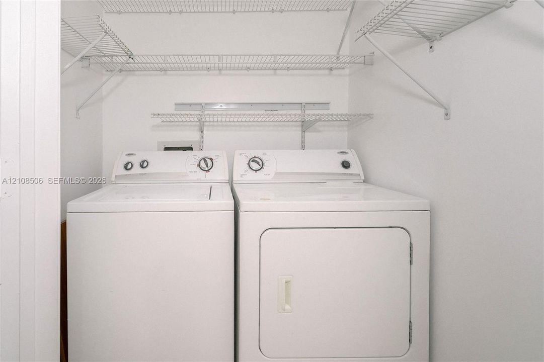 Laundry area featuring multi-level wire shelving and side-by-side appliances