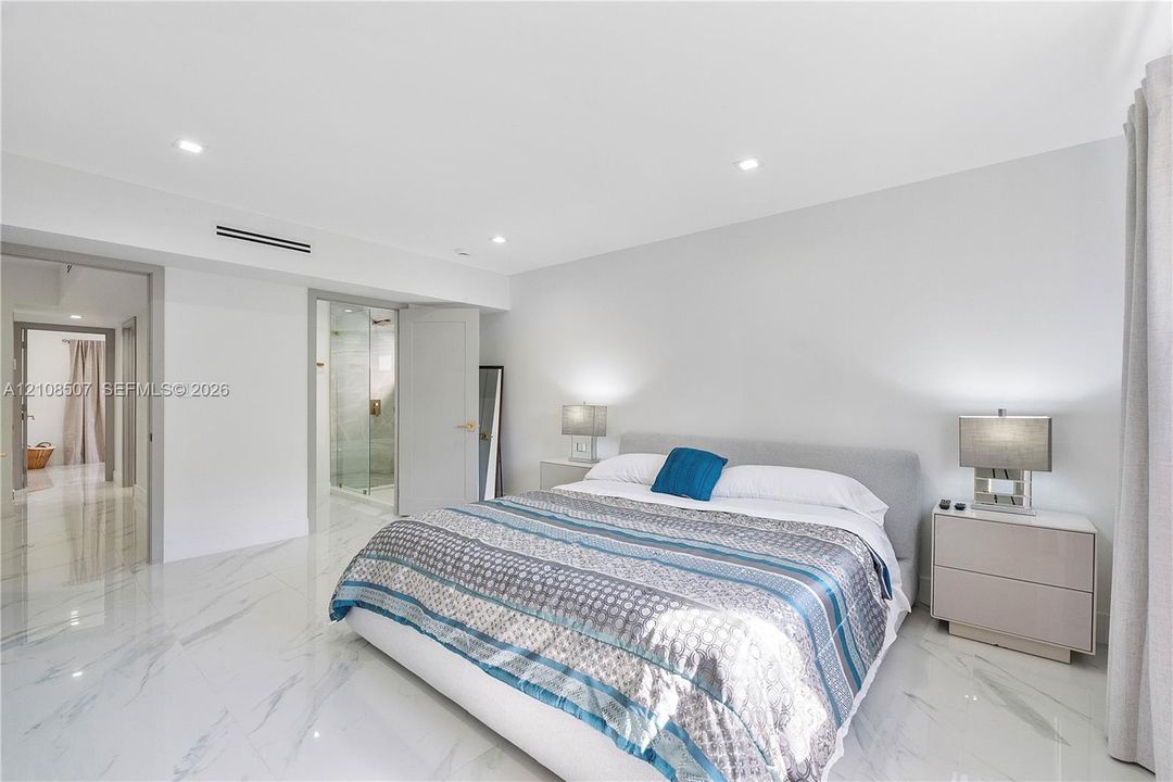 Interior space featuring large-format stone-finish floor tiling, recessed lighting, and high ceilings