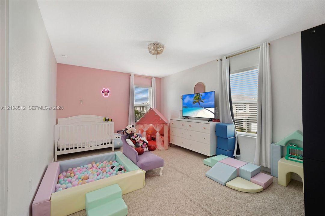 Neutral-toned carpeting, dual windows with natural light, and a flush-mount ceiling light fixture