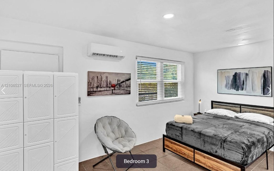 Neutral-tone interior featuring recessed lighting, tile flooring, and a wall-mounted climate control unit