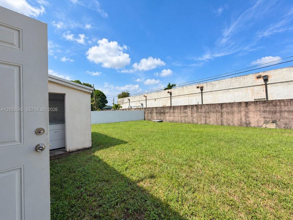 Expansive backyard featuring a level lawn and perimeter masonry wall