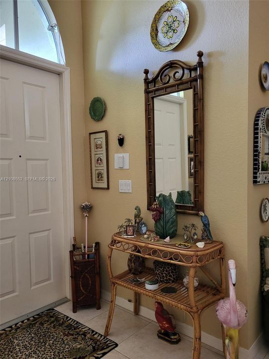 Entryway featuring a multi-panel door with an arched transom window and tile flooring