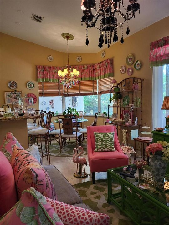 Bay window featuring multi-pane glass, stone-surface breakfast bar, and decorative ceiling medallions with tiered light fixtures