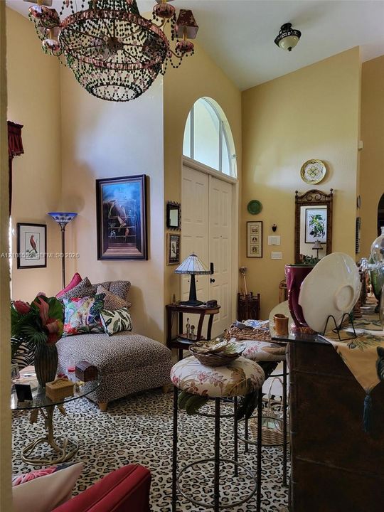 Vaulted ceilings featuring an arched transom window and a decorative multi-tiered chandelier