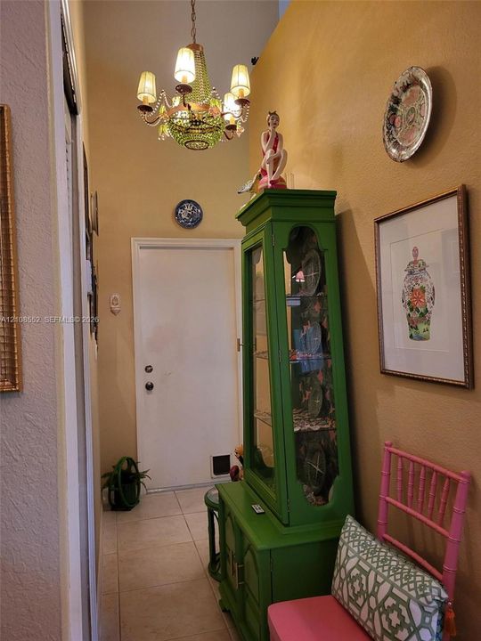 Entryway featuring large-format tile flooring and a multi-arm tiered chandelier