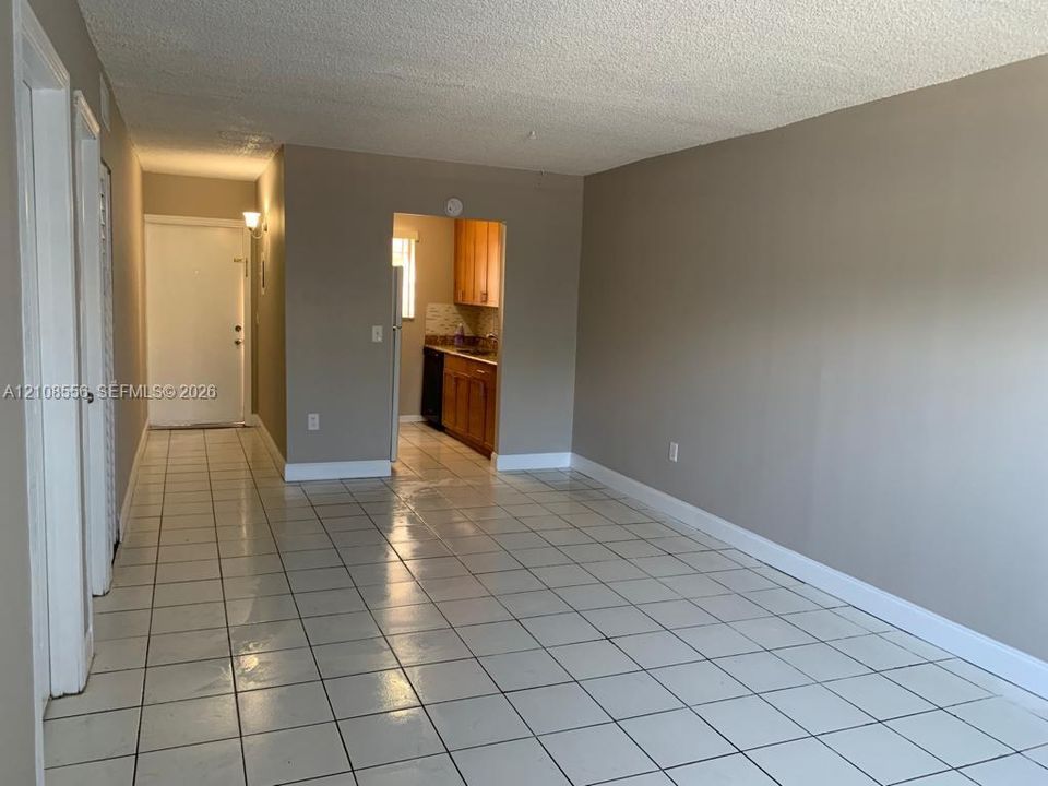 Interior space featuring light-colored tile flooring, neutral wall tones, and built-in cabinetry within the kitchen area