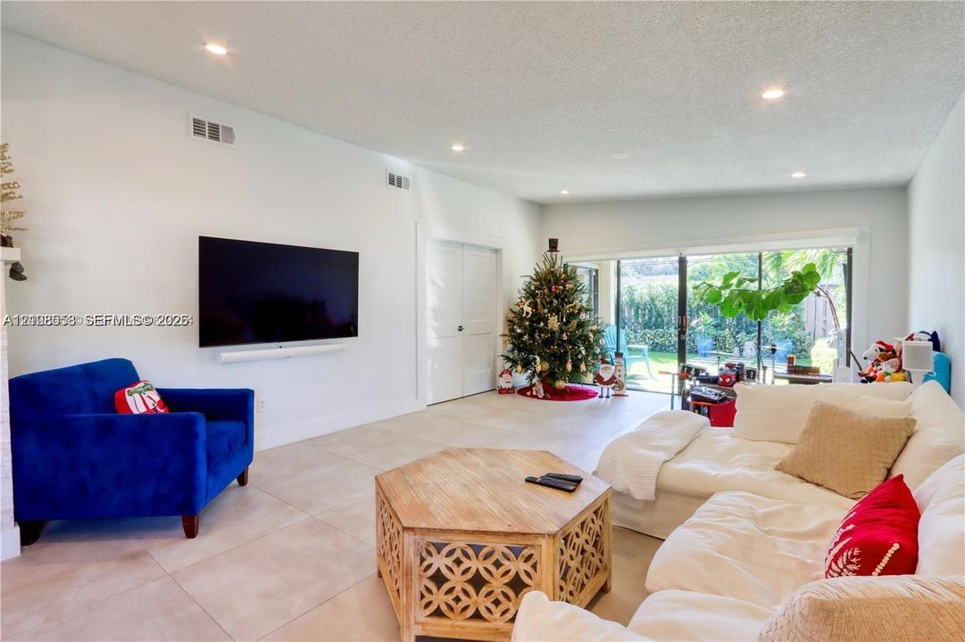 Spacious interior featuring large-format tile flooring, recessed lighting, and expansive sliding glass doors providing natural light