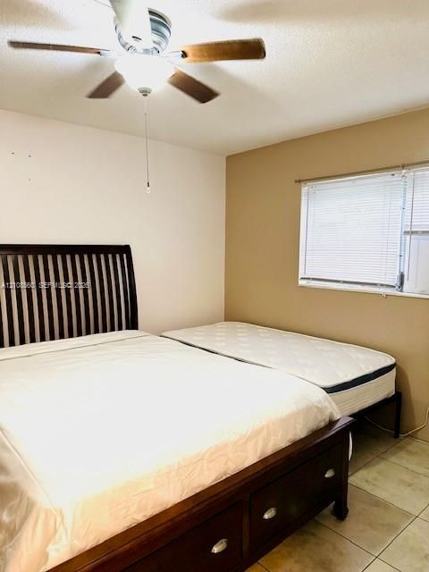 Room featuring tile flooring, neutral wall tones, and a ceiling fan with integrated lighting