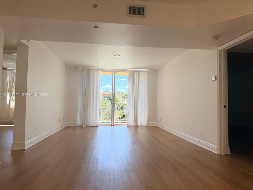 Open-concept interior with wood-finish flooring and glass sliding doors providing exterior access