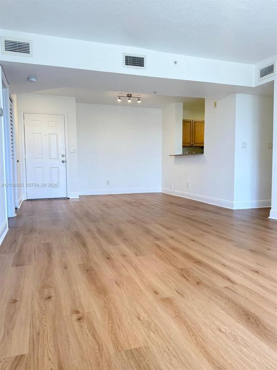 Wood-finish flooring, multi-panel entry door, and recessed track lighting