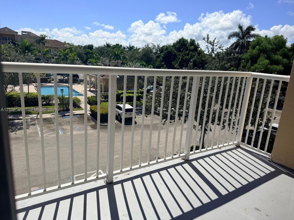 Private balcony with white metal railings and concrete flooring