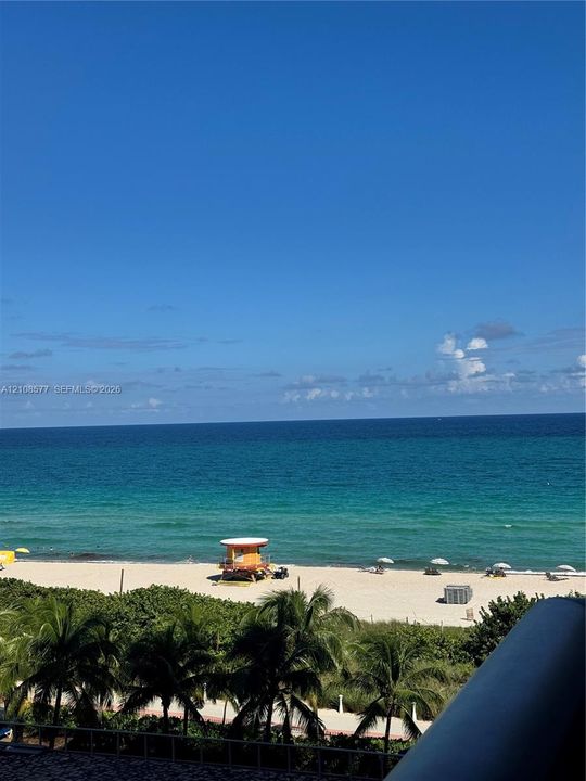 Direct oceanfront exposure with panoramic water scenery, sandy beach access, and lush palm foliage