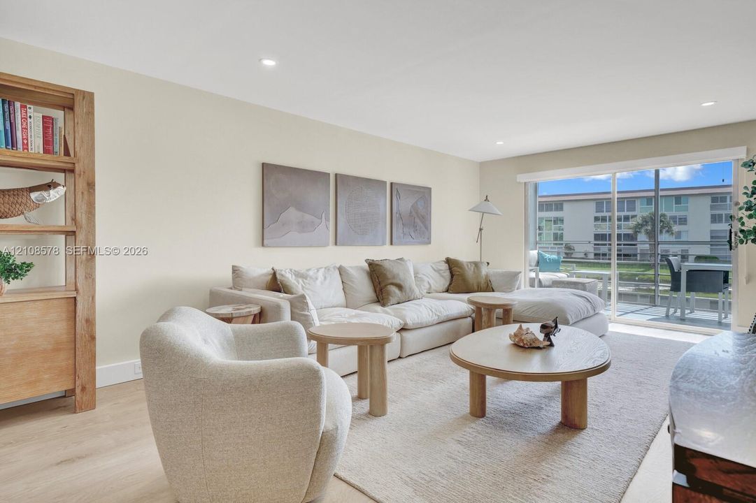 Neutral wall palette featuring wood-finish flooring, recessed lighting, and large sliding glass doors providing outdoor access