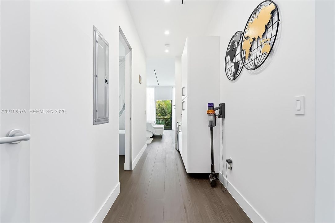 Hallway featuring wood-finish flooring, recessed lighting, and built-in white cabinetry
