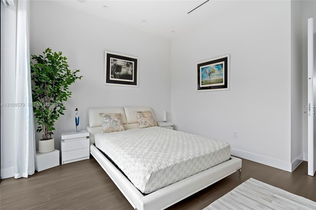 Neutral color palette, wood-finish flooring, recessed ceiling lighting, and smooth-finish walls