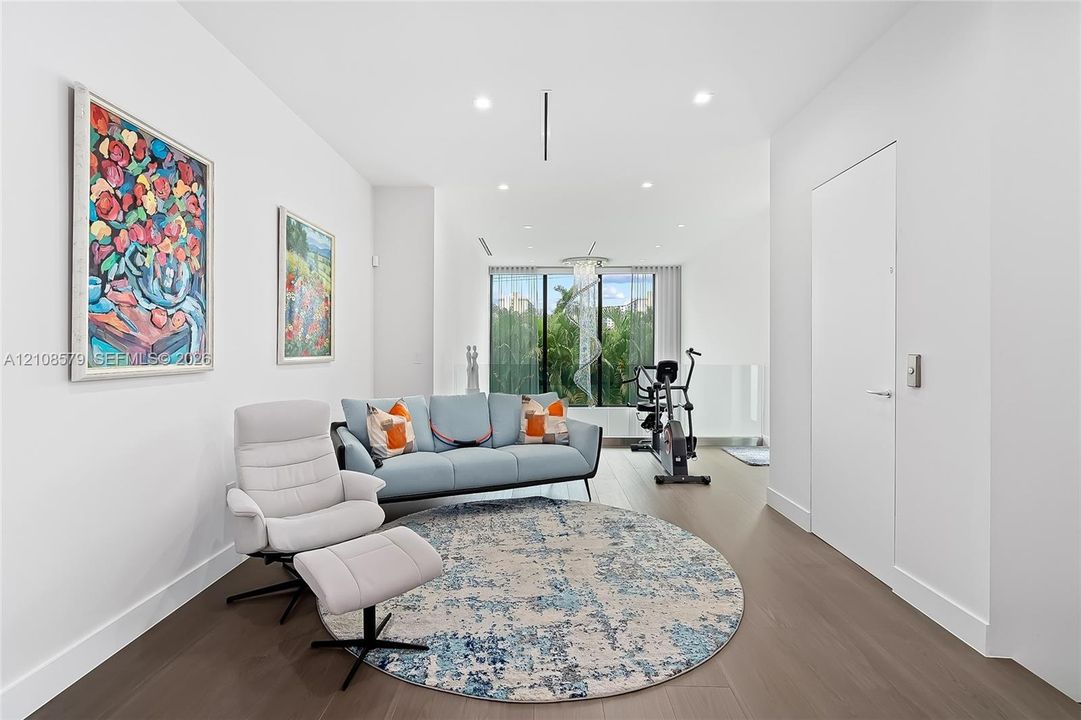 Living area featuring wood-finish flooring, floor-to-ceiling windows, recessed lighting, and a modern sculptural chandelier