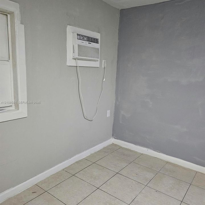 Interior space featuring tile flooring and a wall-mounted air conditioning unit