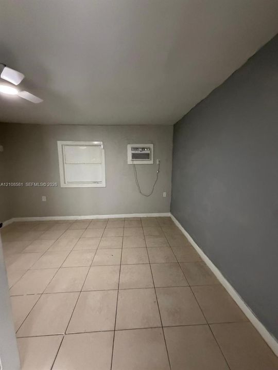 Room featuring large-format ceramic tile flooring, neutral wall paint, accent wall, and a ceiling-mounted light fixture
