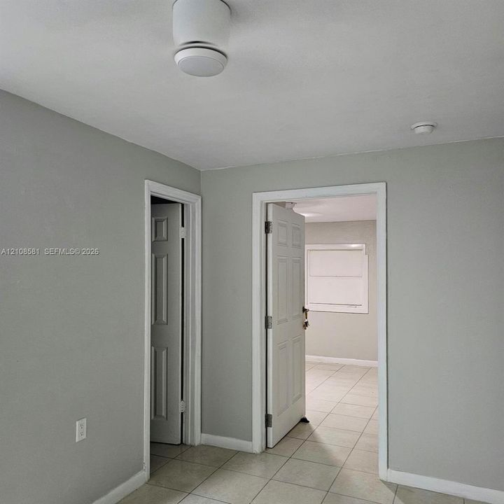 Interior featuring neutral grey wall paint, light-toned ceramic tile flooring, and six-panel interior doors