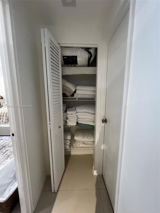Storage closet featuring louvered bifold doors and integrated wire shelving