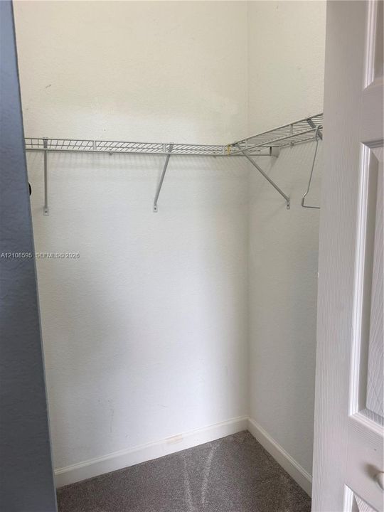 Storage closet featuring gray carpeted flooring and installed wire shelving