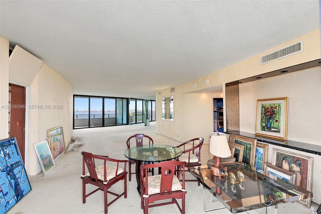 Expansive living space featuring floor-to-ceiling glass doors, wall-to-wall carpeting, and a built-in recessed storage niche with a stone-surfaced ledge
