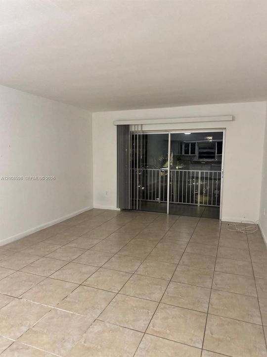 Tiled flooring and sliding glass doors providing outdoor access with an integrated railing