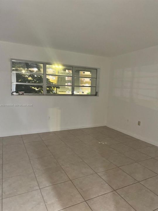 Interior space featuring large-format ceramic tile flooring and multi-pane window with aluminum framing