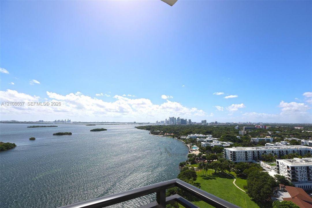 Elevated balcony featuring a metal railing with a panoramic perspective of the bay, coastline, and urban skyline