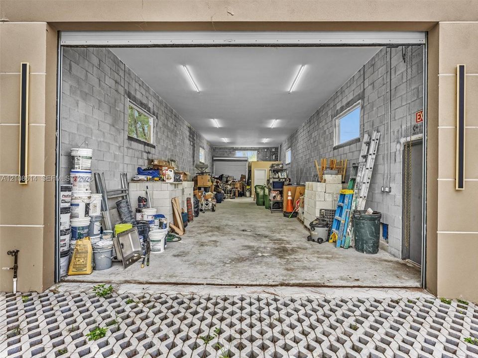 Expansive garage featuring exposed concrete block walls, high-output linear LED lighting, and concrete flooring