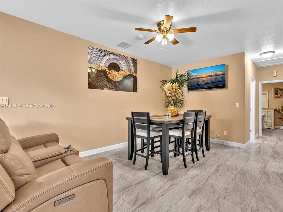 Ceramic tile flooring, neutral wall tones, and ceiling-mounted light fixture with a multi-blade fan