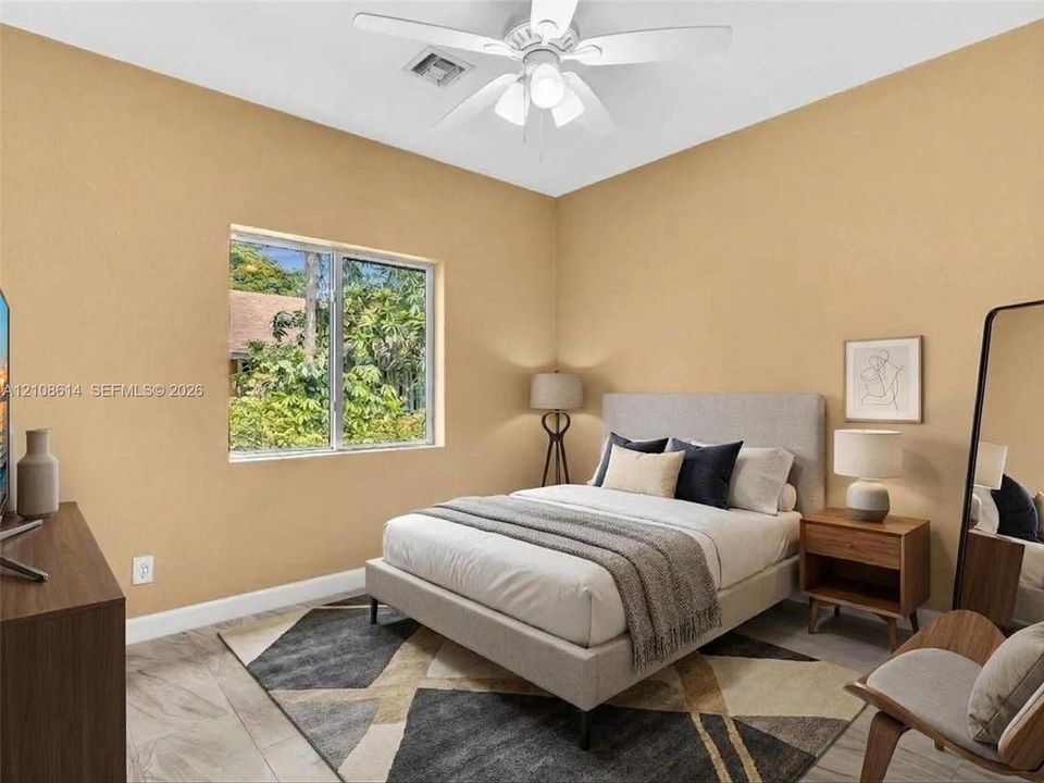 Neutral-toned bedroom featuring large-format tile flooring, a multi-blade ceiling fan with integrated lighting, and a single-pane window