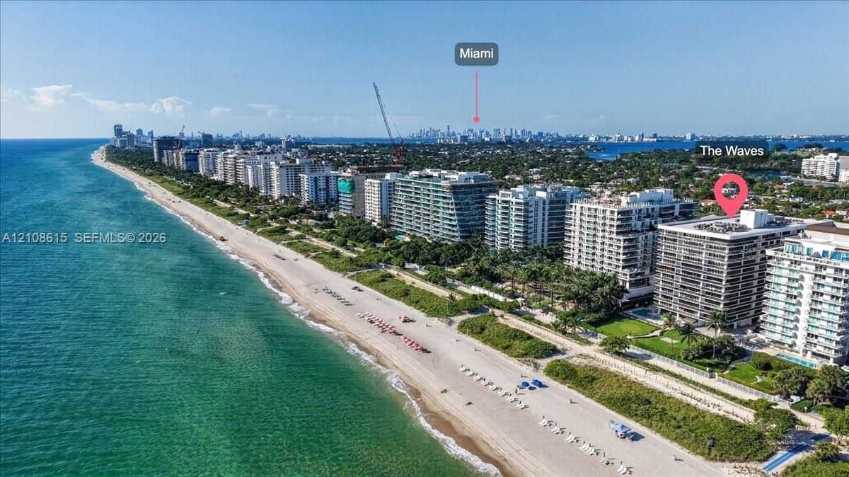 Aerial perspective featuring direct oceanfront positioning, expansive sandy coastline, and proximity to the urban skyline