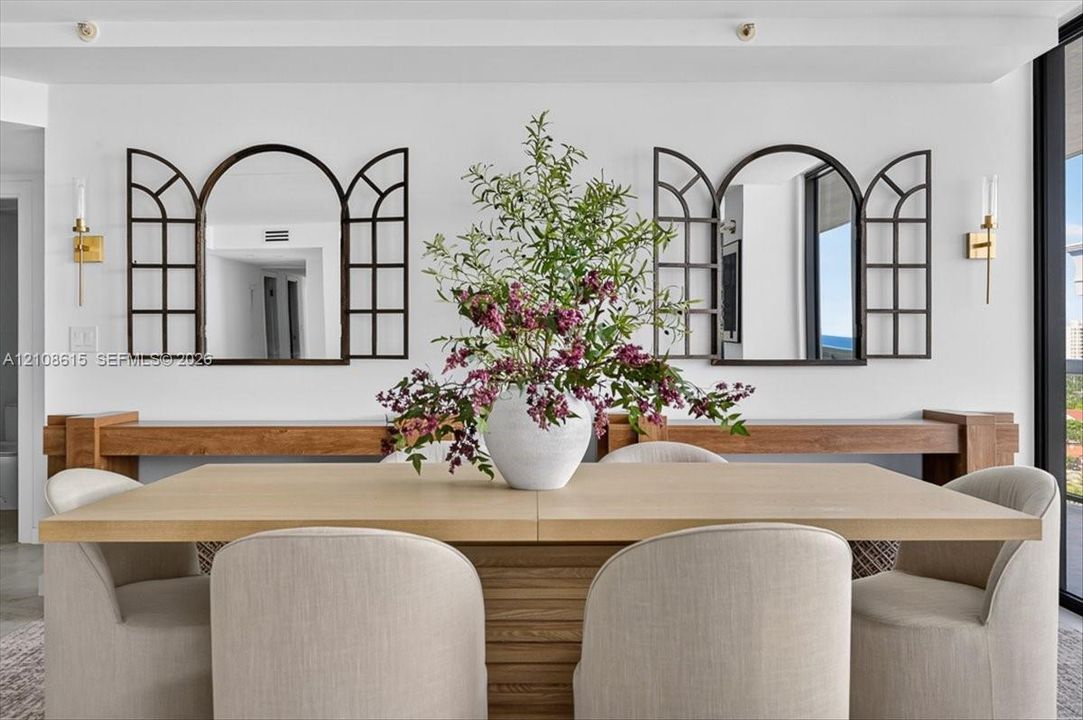 Custom wood wall-mounted consoles with two arched window-pane style decorative mirrors and dual metallic wall-mounted light fixtures