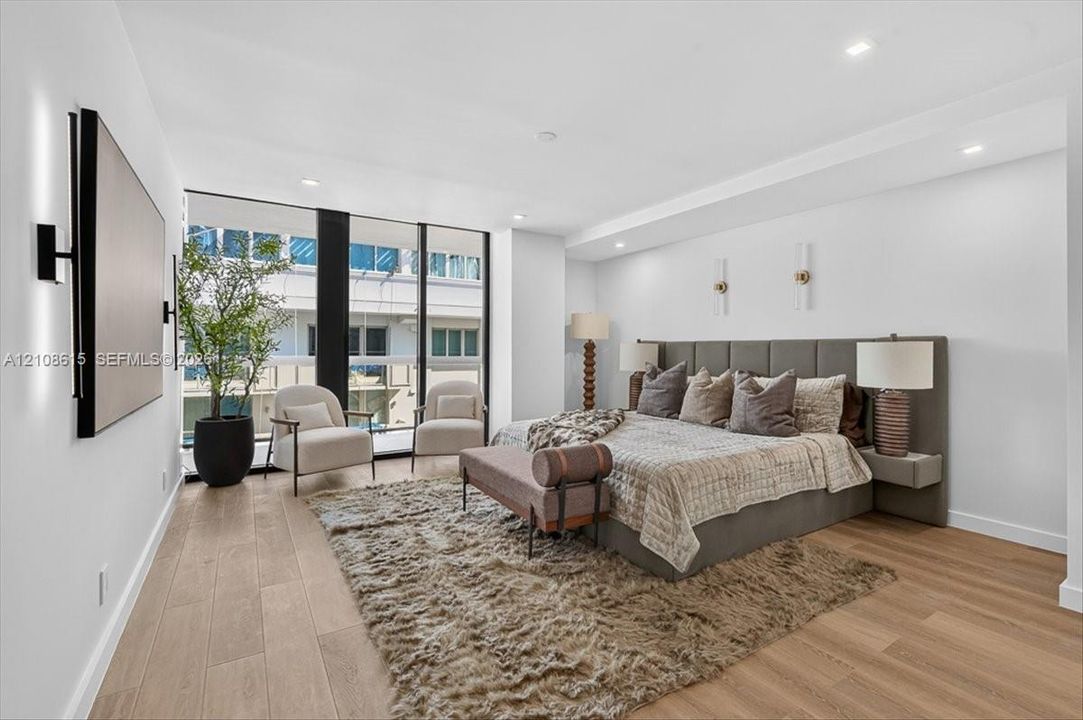 Floor-to-ceiling windows, wood-finish flooring, recessed lighting, and wall-mounted light fixtures